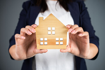 Woman holding a model of a house in her hand