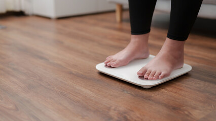 Woman feet standing on digital scales for diet control..