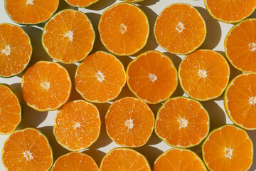 halves of juicy tangerines on a white background. Hard sunlight.