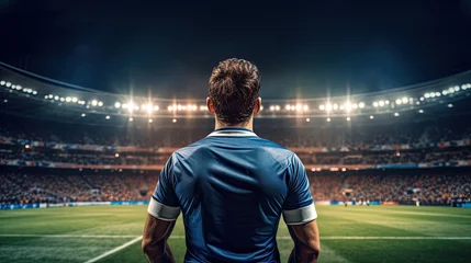 Fotobehang Back view of soccer player standing on the edge of football field © PaulShlykov