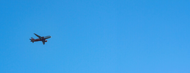 Airplane flying in the blue sky. Concept of fast travel, holidays and business.
