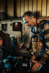 Portrait frame of a manufacturer producing goods on a factory machine.