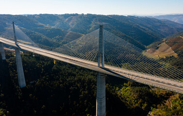 View from drone of Vila Real Bridge, modern cable-stayed suspension viaduct with with concrete deck and supports across green rocky gorge of Corgo river on spring, Portugal - Powered by Adobe