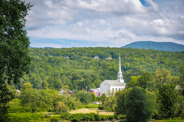 White Stowe Community Church surrounded by forest and mountains, Vermont, New England, United States. Photo taken in August 2023.