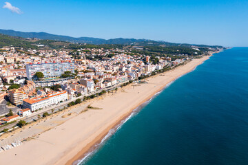 Fototapeta na wymiar Aerial photo of Spanish municipality Canet de Mar with view of beach and residential buildings.