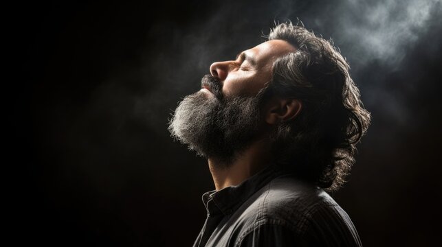 Closeup of a faith leader with closed eyes, his head slightly tilted towards the heavens as he speaks powerful words of healing and strength for the afflicted person in front of him.