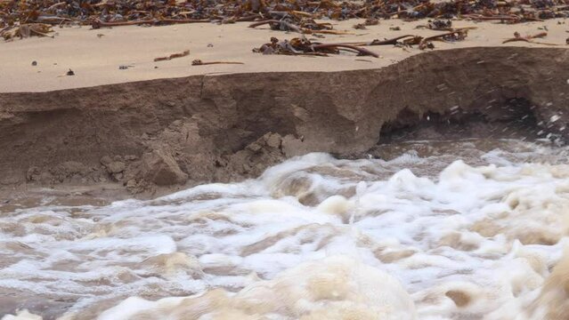 Coastal erosion at a beach caused by cascading flood waters