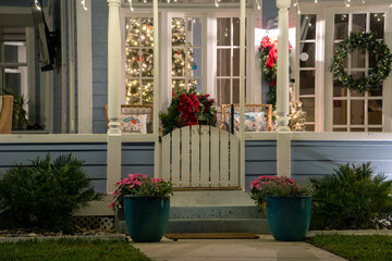 Brightly illuminated Christmas decorations on front yard porch of Florida family home. Outside...