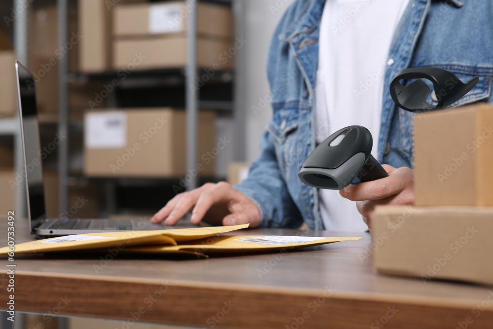 Canvas Prints Seller with scanner, parcels and laptop at table in office, closeup. Online store