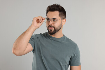 Handsome man wearing glasses on light gray background