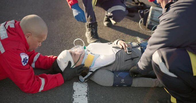 Emergency, healthcare and paramedic on road for injury, accident and car crash for saving patient. Disaster, ambulance and health emt with person for medical service, care and first aid responder