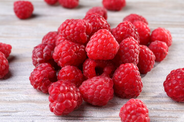 Tasty ripe raspberries on white wooden table, closeup