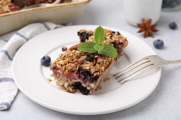 Tasty baked oatmeal with berries on light table, closeup