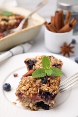 Tasty baked oatmeal with berries on table, closeup