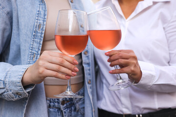 Women clinking glasses with rose wine, closeup