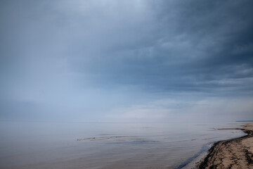 Fading Panorama of the Garciems beach (Garciema Pludmale) in Latvia, on the baltic sea, during a rainy foggy cloudy afternoon. Garciems is one of the sea resorts of Latvia in the baltic states.