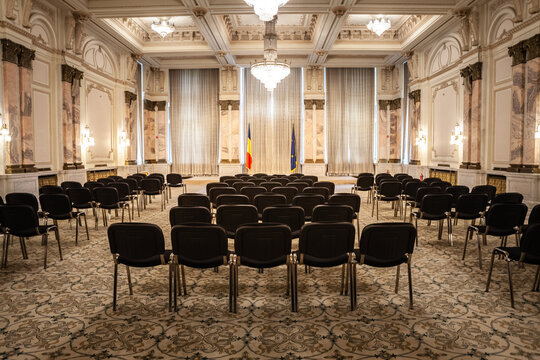 BUCHAREST, ROMANIA - MARCH 13, 2023: Selective blur on empty chairs in a conference hall with opulent design in the interior of Romanian palace of parliament in Bucharest symbol of romanian communism.
