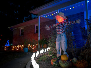 Halloween Pumpkin head scarecrow in front of house