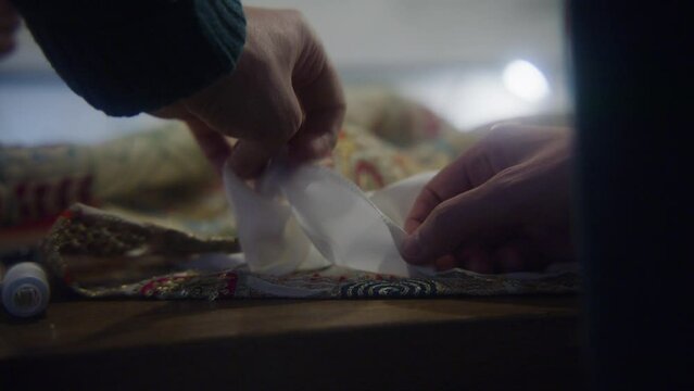 Close up of hands working on  fabric and textiles