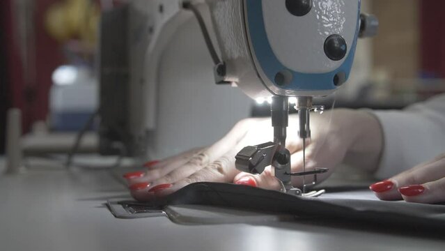 This stock video shows the hands of a seamstress who sews on a sewing machine. This video will decorate your projects related to sewing, industry, seamstress profession.
