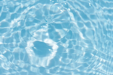 Defocus blurred transparent blue colored clear calm water surface texture with splashes reflection. Trendy abstract nature background. Water waves in sunlight with copy space. Blue watercolor shine.
