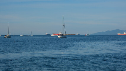 Fototapeta premium Yachts in the harbor on a beautiful sunny day. Luxury boats and large ships