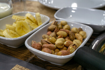 Mixed nuts in a bowl on a wooden table, close up
