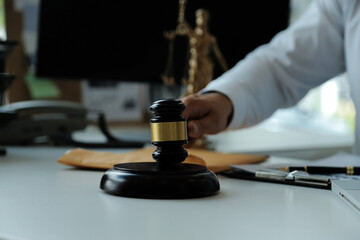 Judge gavel with Justice lawyers having team meeting at law firm in background. Concepts of law.