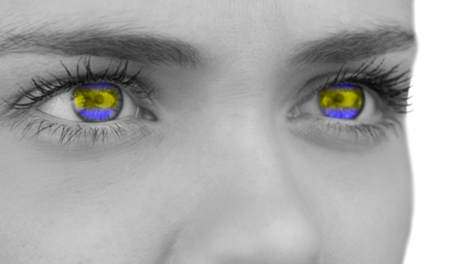 Digital png photo of woman's eyes in ukraine flag colours on transparent background