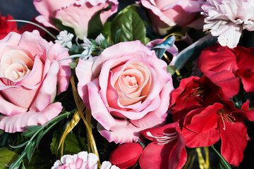 Pink rose. Cotton flowers composition. Funeral bouquet. Floral background. Plastic floral decorations bouquet. Bright white and red roses. Rose flower closeup. Artificial flower looks like real.