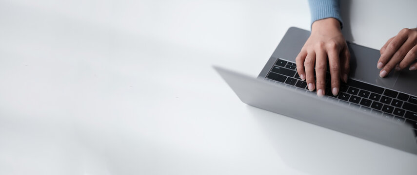 Businesswoman hands using laptop computer placed on desktop.