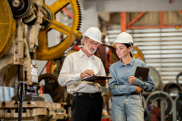 woman engineer assistant secretary in helmet inspection check control heavy machine construction installation in industrial factory with boss manager. Boss and partnership check maintenance factory