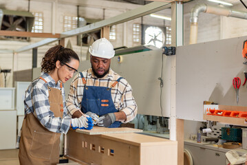 Two colleague young aged carpenter standing aim equipment tool for wood furniture at wood plank in workshop. coworker carpenter working craft with wood diy tool in workbench shop carpentry