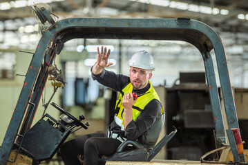 Portrait of forklift truck driver man smiling in old factory warehouse lifting pallet in storage shipping. forklift truck driver mail inside old forklift smiling to worker employee in warehouse store.