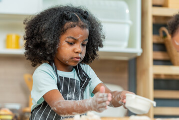 african afro black daughter kids sifting flour powder and sprinkling ingredients on massaging dough...