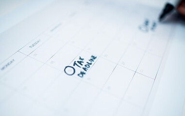 Person, calendar and date for tax, deadline or reminder in schedule planning or strategy on desk at office. Closeup of writing, paper or agenda for memory, financial plan or daily tasks at workplace