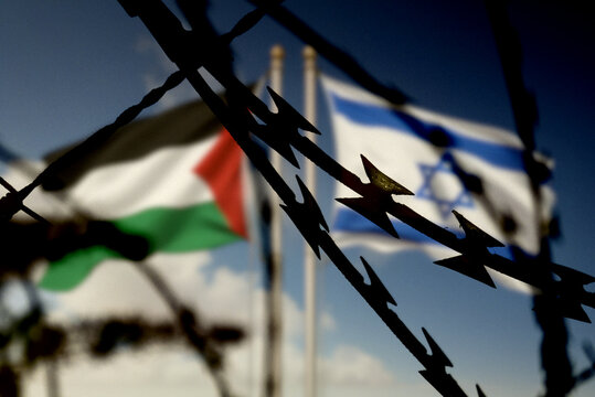 Flaggen von Israel und Palästina hinter dem Stacheldraht