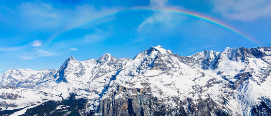The mountain view of   rainbow scene with alpine as snow-capped mount peaks in  Winter mountains