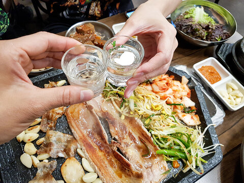 Holding a glass of soju