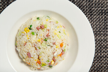 Fried rice with ham and vegetables on a plate