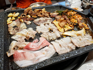 Meat and vegetables grilled on an iron plate