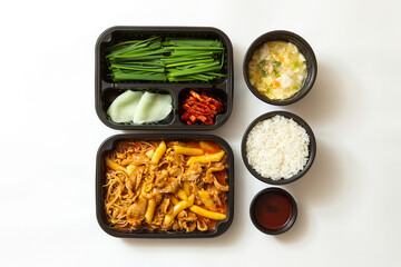 Stir-fried pork and side dishes in a lunch box container
