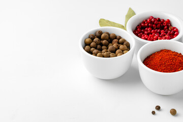 Various spices in a bowls on white background