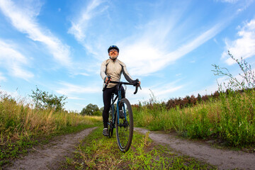 Naklejka premium bearded man cyclist rides a bike on a road in nature. sports, hobbies and entertainment for health