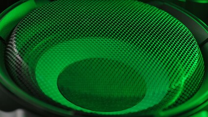 Subwoofer with membrane green neon light moving vibrating, macro sound bass circles, abstract...