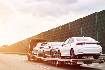 Tow truck with a cars on the highway road. Tow truck transporting car on the autobahn. Car service...