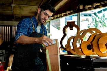 Luthier Sanding Acoustic Guitar Body in Workshop