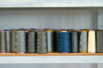 Row of multicolored thread spools at sewing factory