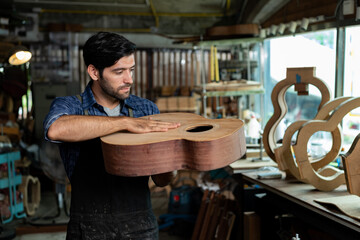 Luthier Taps Spruce Top of Unfinished Acoustic Guitar to Check Sound Quality