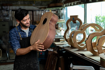Luthier Taps Spruce Top of Unfinished Acoustic Guitar to Check Sound Quality
